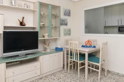 a living room with a tv and a table and chairs at Apolo, 3º-16 in Cullera