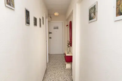 a corridor of a hallway with paintings on the walls at Apolo, 3º-16 in Cullera