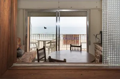 a living room with a table and a view of the ocean at Apolo, 5º- 30 in Cullera