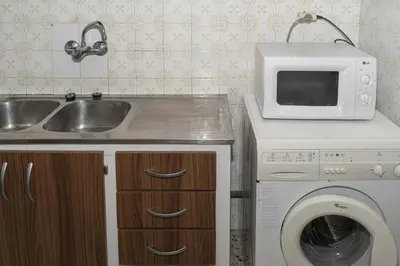 a kitchen with a sink and a washing machine at Apolo, 5º- 30 in Cullera