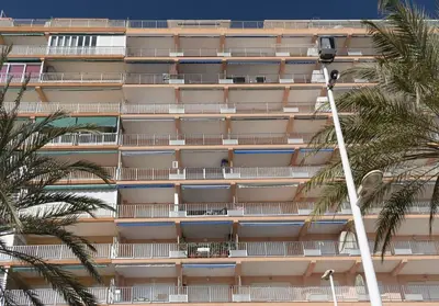 an apartment building with balconies and palm trees at Apolo, 5º- 30 in Cullera