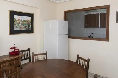 a kitchen with a table and a white refrigerator at Apolo, 5º- 30 in Cullera