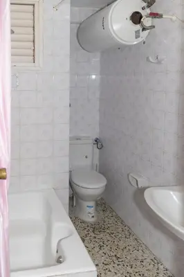 a white bathroom with a toilet and a sink at Apolo, 5º- 30 in Cullera