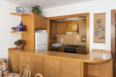 a kitchen with wooden cabinets and a white refrigerator at Arensol Esc-A, 13º-51 in Cullera