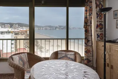 a table and chairs in a room with a balcony at Arensol Esc-A, 13º-51 in Cullera