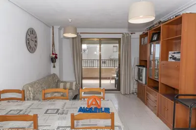 a living room with a table and chairs and a dining room at Dosel, 6º-30 in Cullera