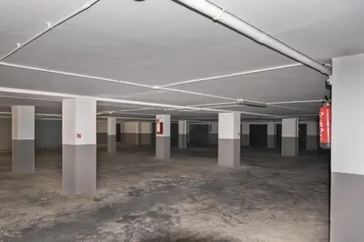 an empty parking lot with white columns in a building at Dosel, 6º-30 in Cullera