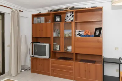 a wooden entertainment center with a television in a room at Dosel, 6º-30 in Cullera