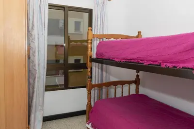a bedroom with two bunk beds with purple sheets at Estirpe, 2º-4 in Cullera