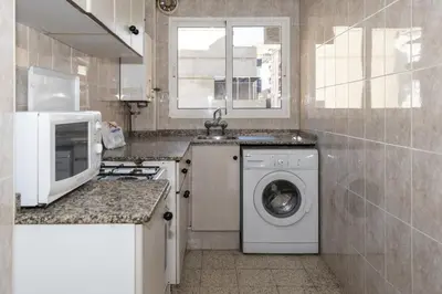 a kitchen with a washing machine and a microwave at Estirpe, 3º-6 in Cullera