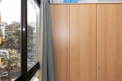 a wooden cabinet in a room with a window at Estirpe, 3º-6 in Cullera