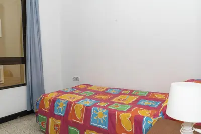 a bed with a colorful blanket in a room at Estirpe, 4º-8 in Cullera