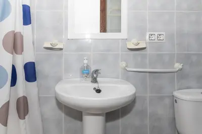 a bathroom with a sink and a toilet and a mirror at Estirpe, 4º-8 in Cullera