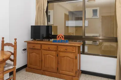 a television on top of a wooden dresser in a room at Estirpe, 4º-8 in Cullera