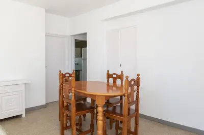 a dining room with a wooden table and chairs at Estrella, 6º-36 in Cullera