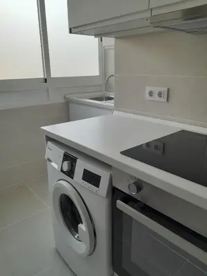 a kitchen with a washing machine under a counter at Estrella, 6º-36 in Cullera