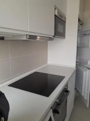 a kitchen with white cabinets and a black counter top at Estrella, 6º-36 in Cullera