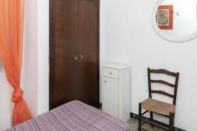 a bedroom with a bed and a chair and a mirror at Europa B 6º-23 in Cullera