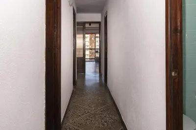 a hallway with white walls and a tile floor at Europa B 6º-23 in Cullera