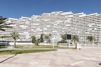 a large white building with palm trees in front of it at Florazar 1, I-A 7-B in Cullera