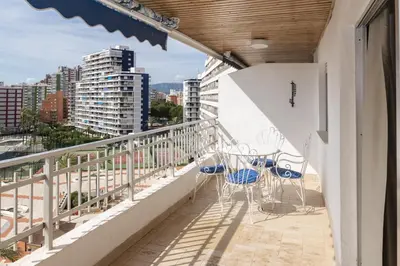 a balcony with chairs and tables on a building at Florazar 1, Iii-B 8-B in Cullera