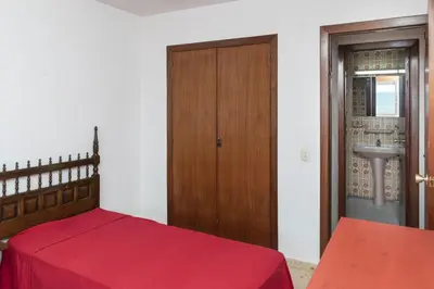 a bedroom with a bed and a wooden door at Florazar 1, Iii-B 8-B in Cullera