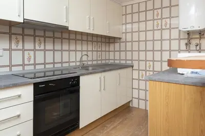 a kitchen with white cabinets and a black dishwasher at Florazar 2, Ix-7-B in Cullera