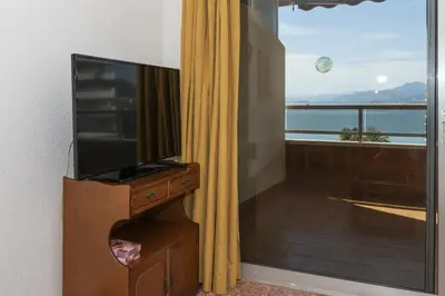 a flat screen tv sitting on a dresser next to a window at Florazar 2, Ix-9-C in Cullera