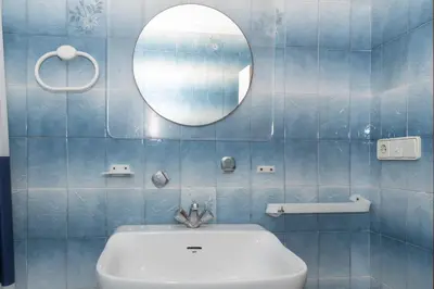a blue tiled bathroom with a sink and a mirror at Florazar 2, Ix-9-C in Cullera
