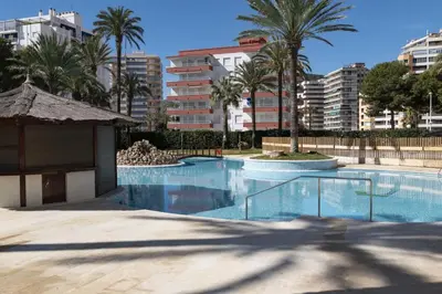 a large swimming pool with palm trees and buildings at Florazar 2, Ix-9-C in Cullera