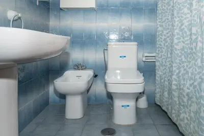 a blue tiled bathroom with a toilet and a sink at Florazar 2, Vi-10-B in Faro de Cullera
