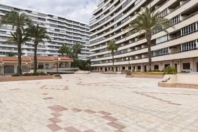a courtyard with palm trees and a large building at Florazar 2, Vi-13-C in Faro de Cullera