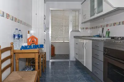 a kitchen with white cabinets and a table and a sink at Florazar 2, Vi-15-A in Cullera