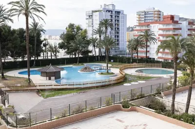 a view of two pools with palm trees and buildings at Florazar 2, Vi-1-B in Cullera