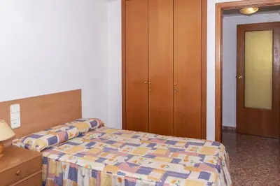 a bedroom with a bed and a wooden cabinet at Florazar 2, Vi-1-B in Cullera