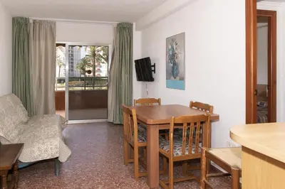 a dining room with a table and chairs and a television at Florazar 2, Vi-1-B in Cullera