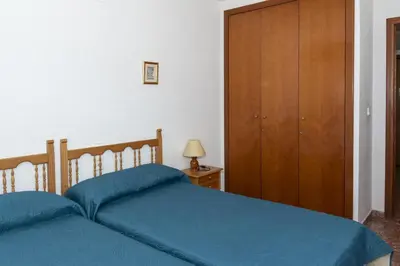 a bedroom with two beds and a wooden cabinet at Florazar 2, Vi-3-B in Faro de Cullera