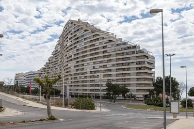 a large white building with a tree in front of it at Florazar 2, Vi-3-B in Faro de Cullera