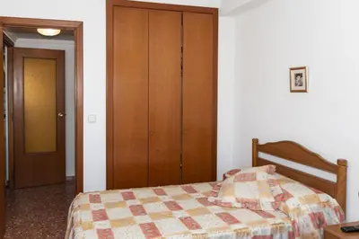 a bedroom with a bed and a wooden closet at Florazar 2, Vi-7-C in Cullera