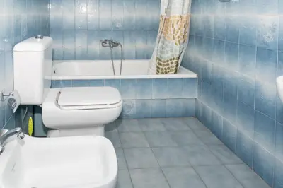 a blue tiled bathroom with a toilet and a tub at Florazar 2, Vi-7-C in Cullera