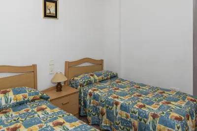 a bedroom with two beds and a table with a lamp at Florazar 2, Vii-2-A in Faro de Cullera