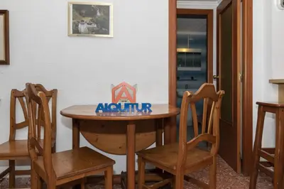 a wooden table with two chairs and a sign on it at Florazar 2, Viii-8-B in Cullera