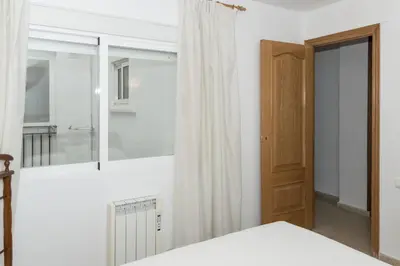 a white bedroom with a bed and a mirror at Frontalmar, Esc-A, 8º-29 in Cullera