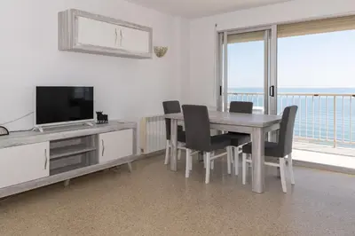 a dining room with a table and chairs and a television at Frontalmar, Esc-A, 8º-29 in Cullera