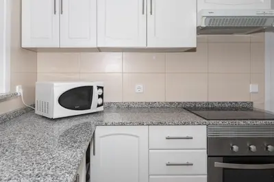 a white microwave oven sitting on a kitchen counter at Frontalmar, Esc-B, 8º-32 in Cullera
