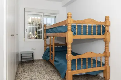 a wooden bunk bed in a room with a window at Hawai Bajo in Faro de Cullera