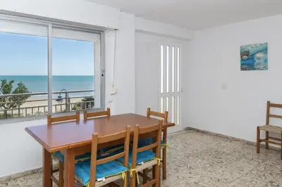 a dining room with a table and a view of the ocean at Hawai Bajo in Faro de Cullera