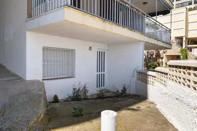 a white building with a balcony on the side of it at Hawai Bajo in Faro de Cullera
