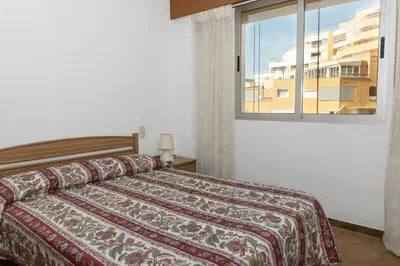 a bedroom with a bed and a window at Las Vegas, Esc-3, 7º-19 in Cullera