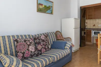 a living room with a couch and a refrigerator at Las Vegas, Esc-3, 7º-19 in Cullera